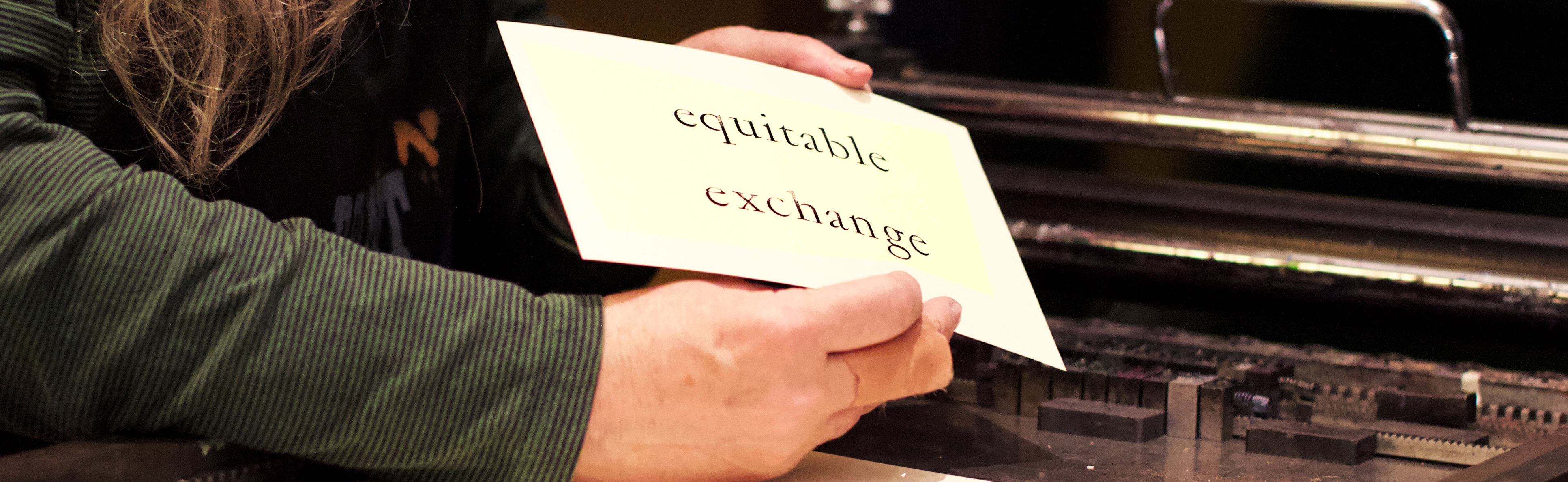 hand holding paper that says "equitable exchange"