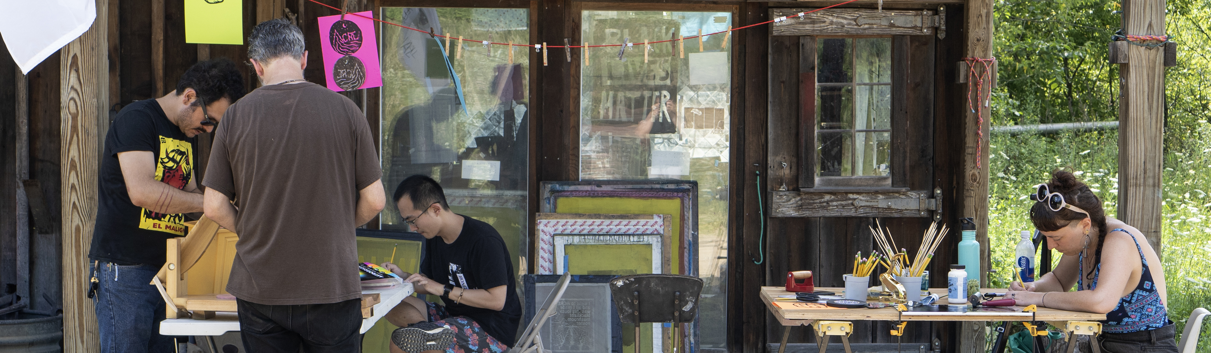Four artists work in an outdoor studio space