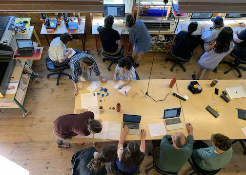 A photo take from above of people sitting at tables and desks. 