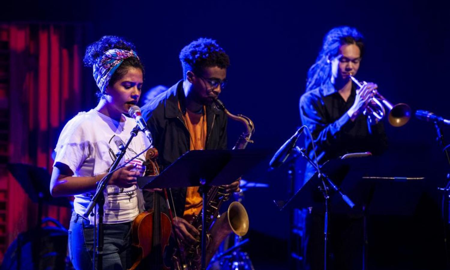 Three musicians performing on stage