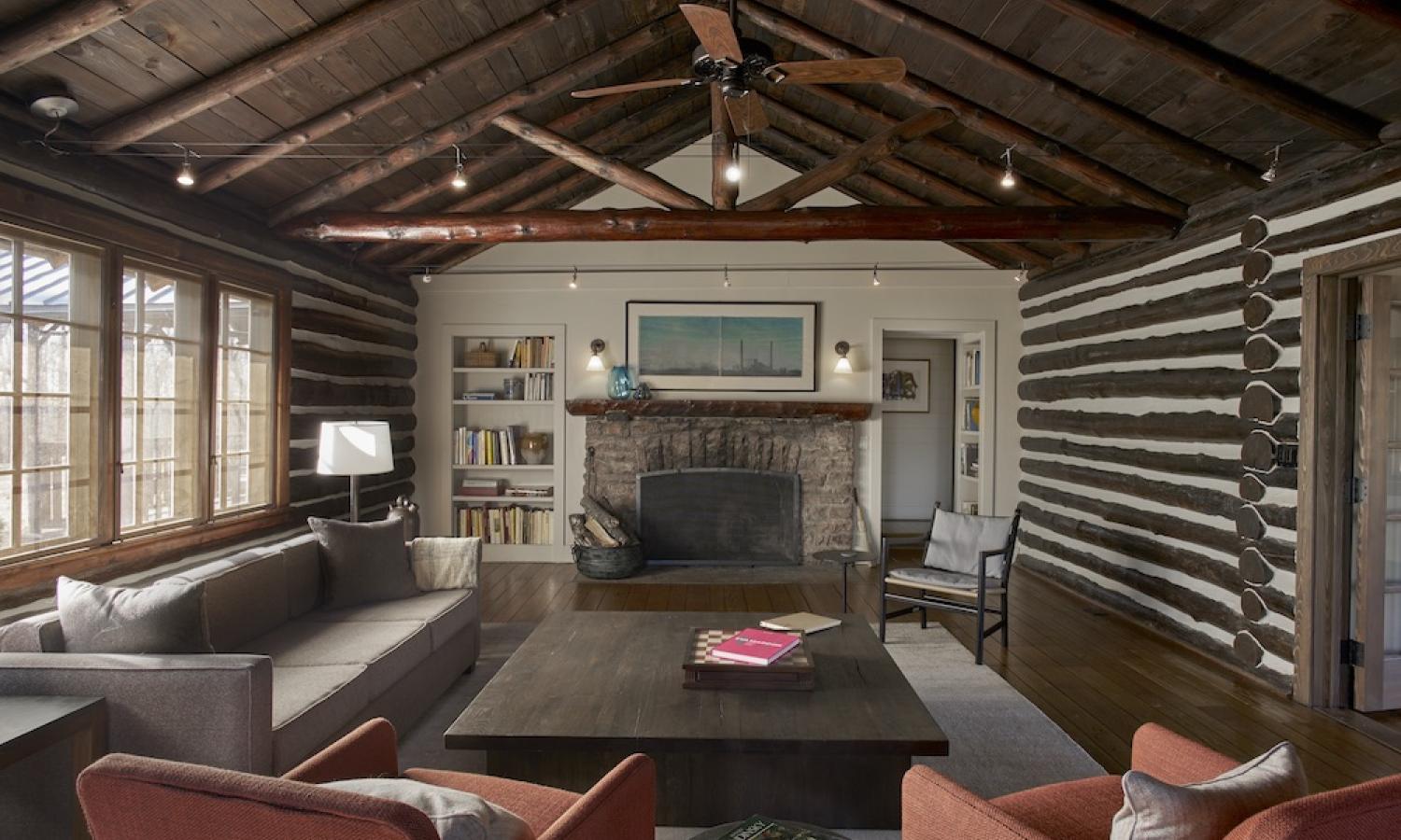Living room in Cabin 900 showing a couch, a chair, fireplace and other furnishings