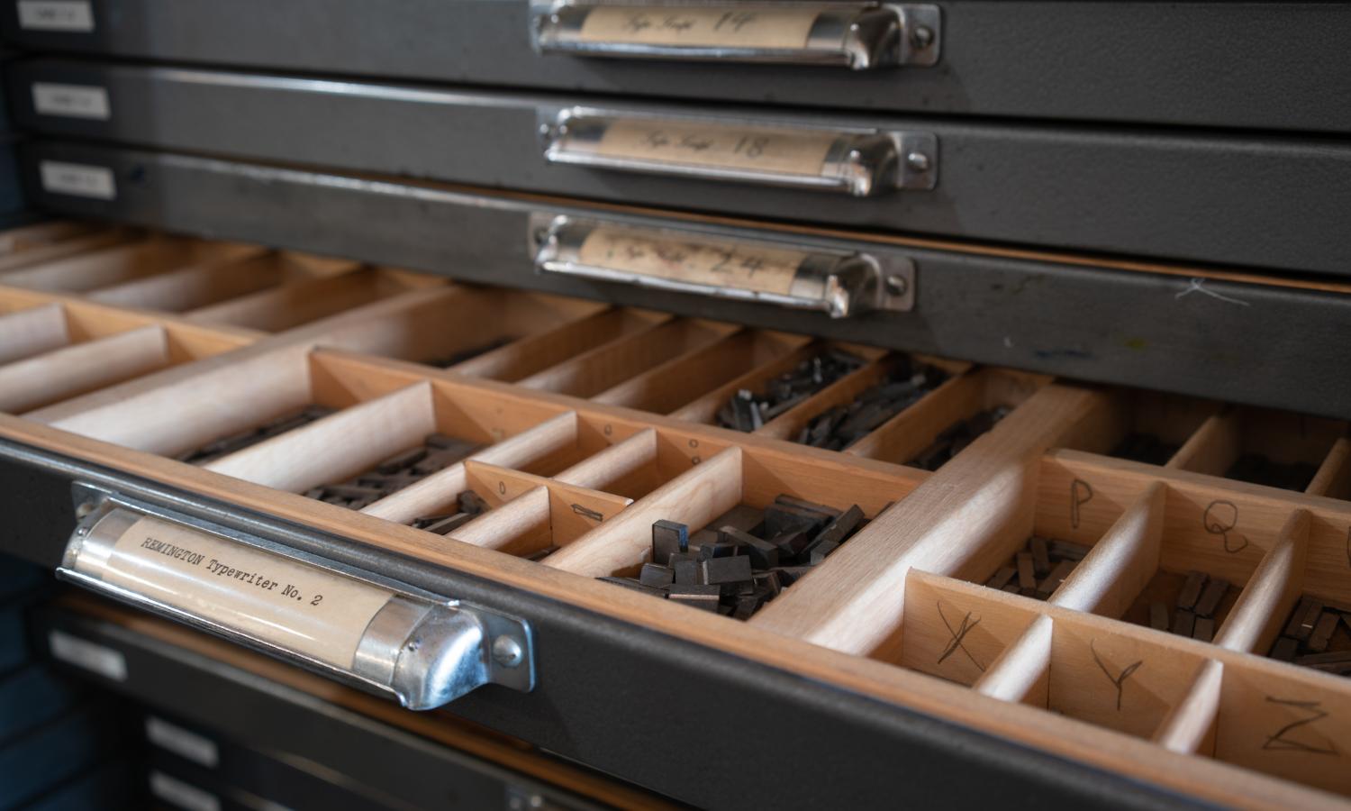 A type cabinet displaying various letters of type used for letterpress printing.