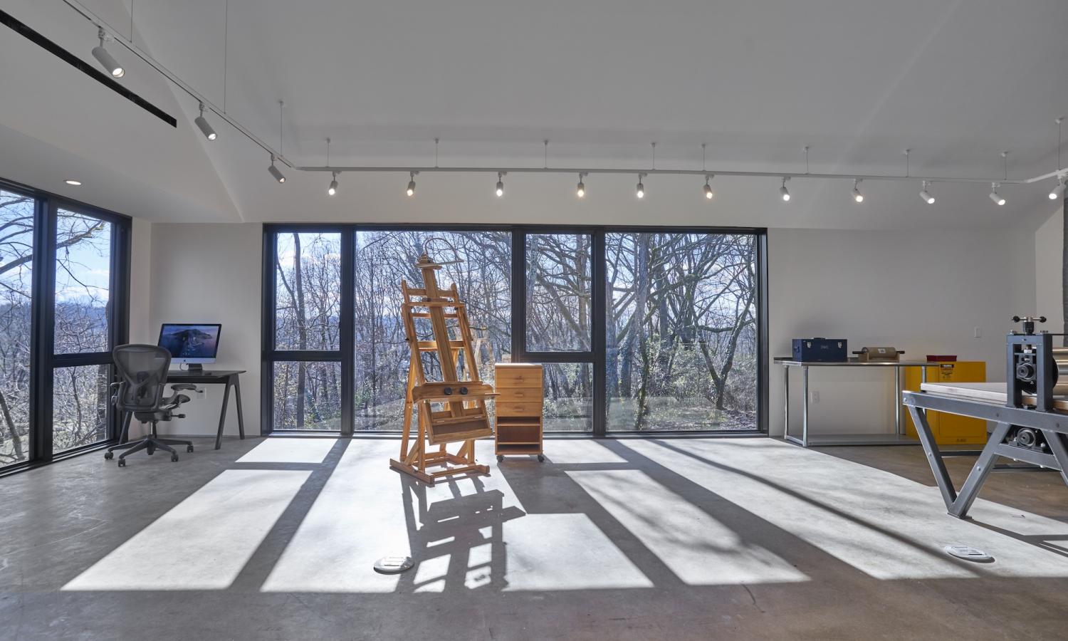 Interior of Visual Arts Studio showing computer, wooden easel, taboret, and press