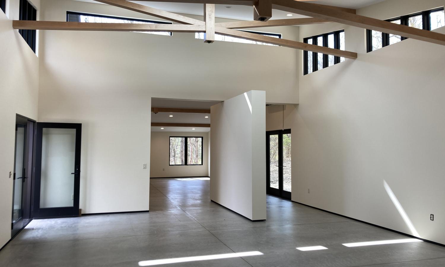 an accessible space with cement floors and a pivoting wall leading into a large studio