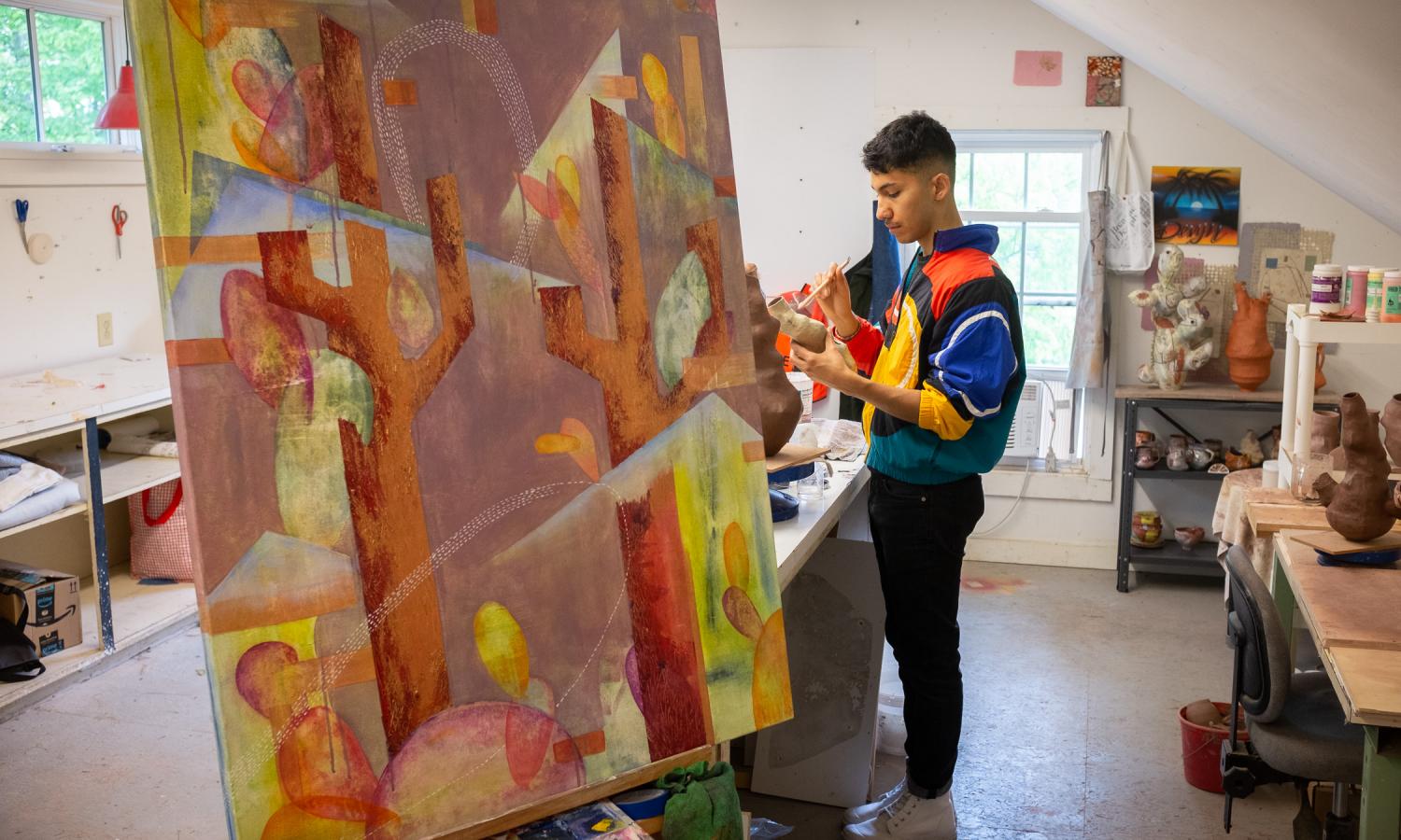 Core Fellow Tony Santoyo working between a large painting and ceramic surfaces
