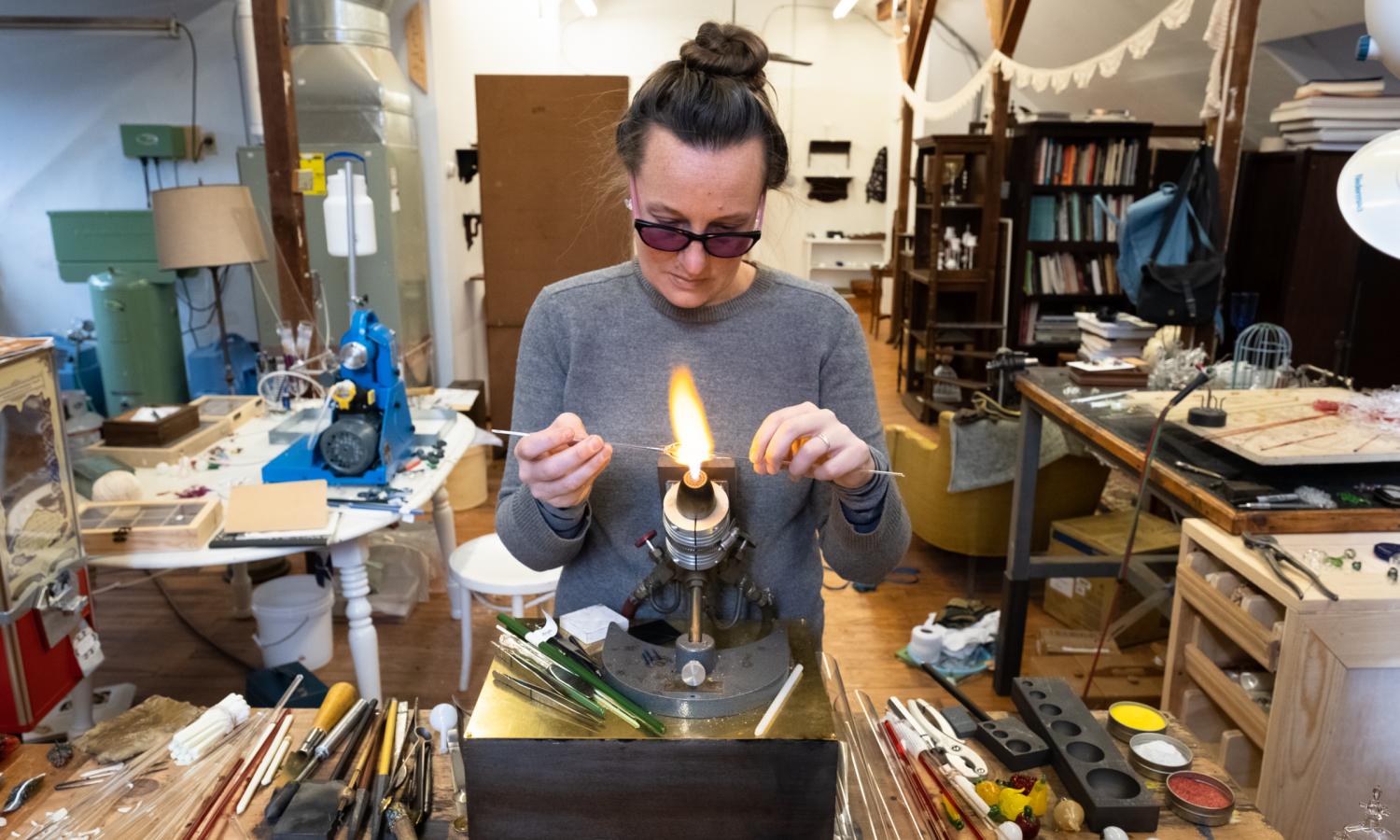 Glass artist Kit Paulson works at the torch in her studio