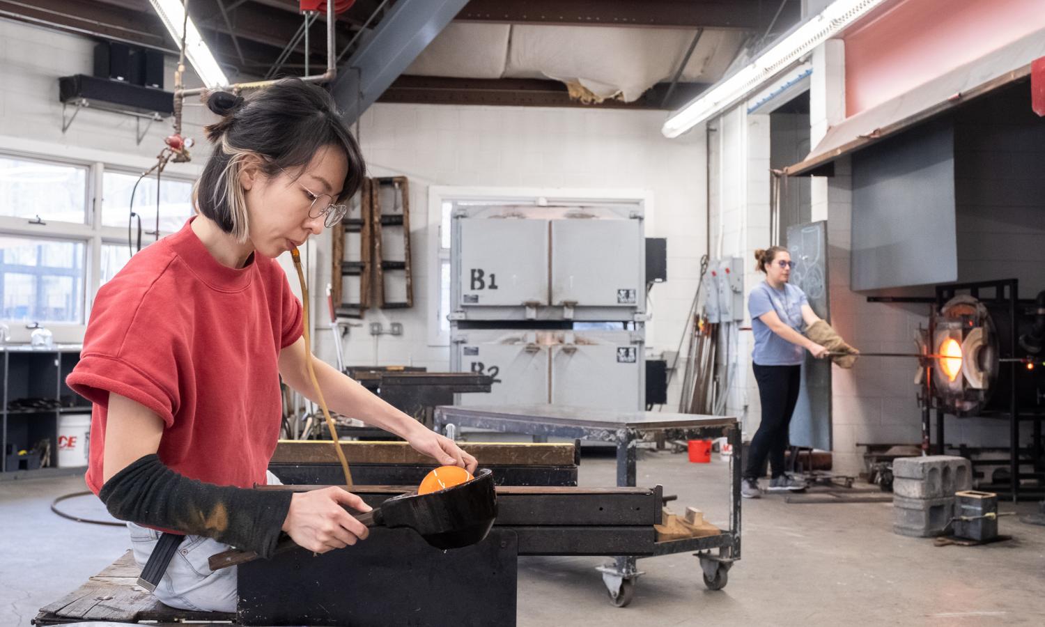 Glass artist Ying Chiun Lee working in the hot shop during Winter Residency