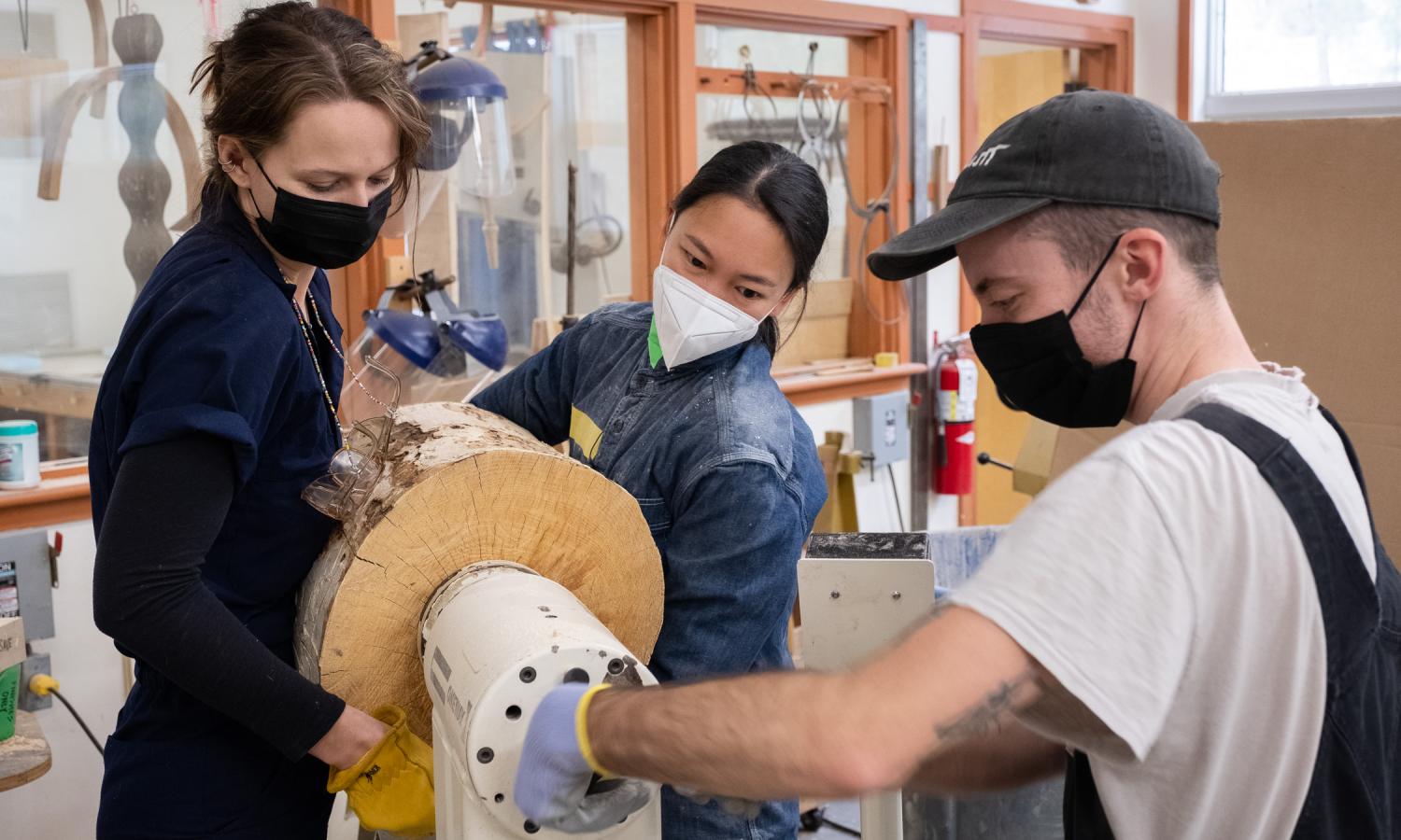 Winter resident Vivian Chiu gets some assistance on the lathe from wood studio staff