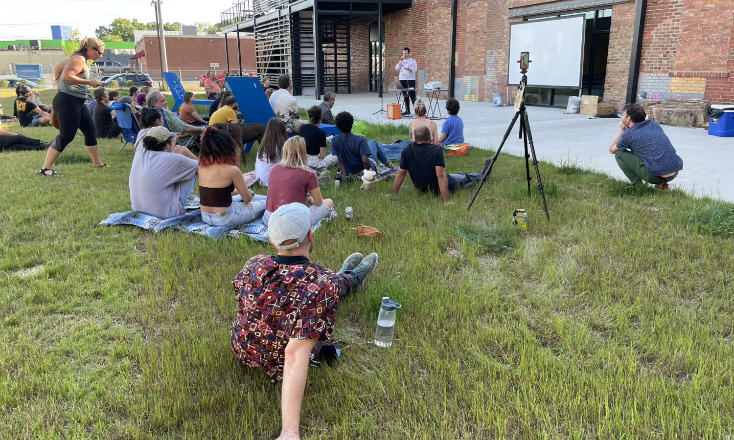 residents and audience members watching an artist in residence present on their work in the courtyard