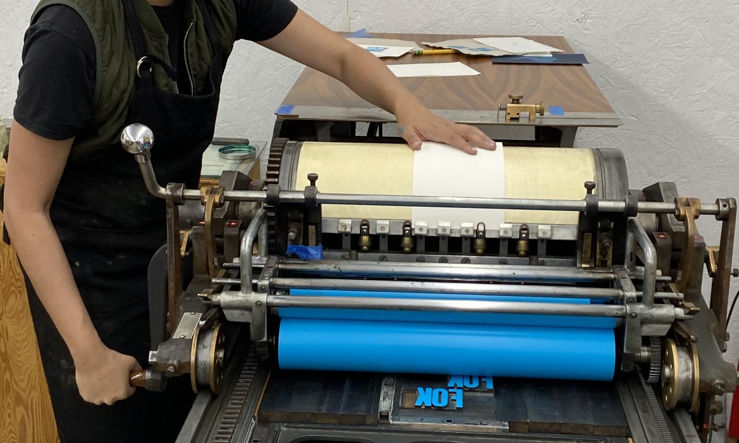 Print resident artist May Maylisa Cat operates a Vandercook press to make a letterpres print.