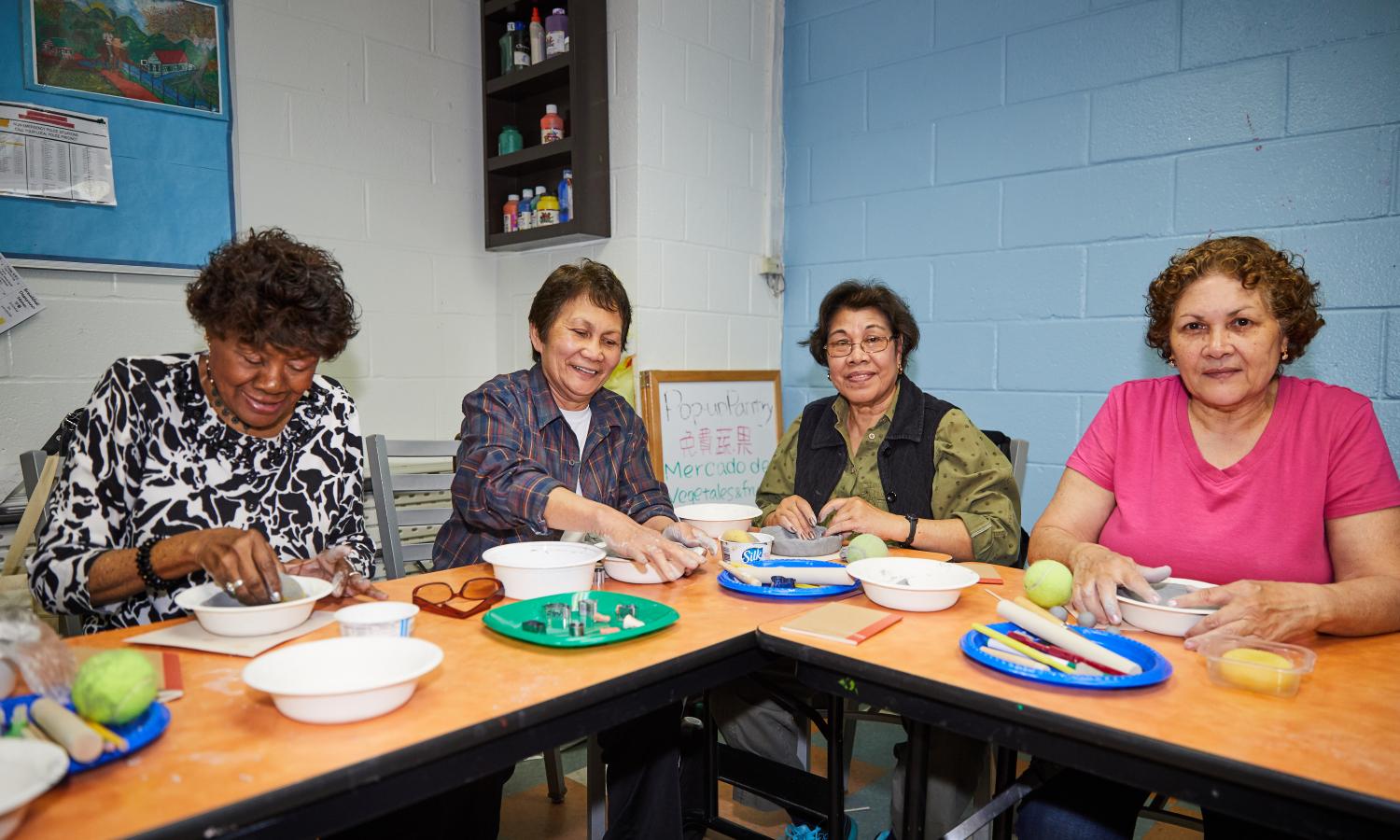 Residents at Grand Street Settlement make clay bowls.