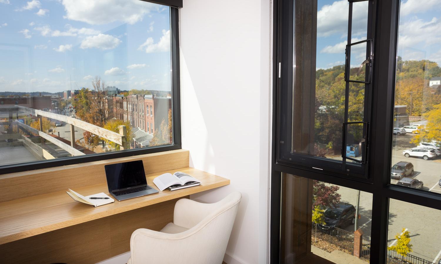 Personal desk space within Bedroom Three. Glimpse of outdoor rooftop patio space.