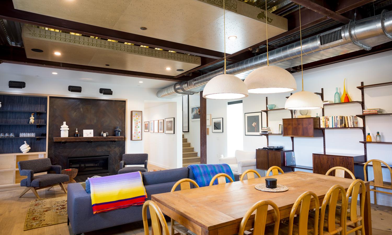 Open shared living and dining areas. Located on the main apartment level accessible by stairs or elevator. Stairs leading to the top apartment floor and hallway leading to the ADA compliant bathroom, bedroom, shared laundry room, and main apartment entrance.