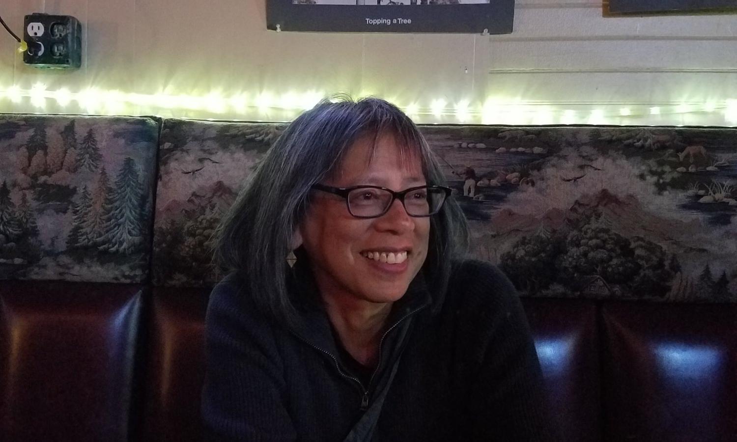 A writer smiles from a booth inside of the Headquarters Tavern, in walking distance to the school.