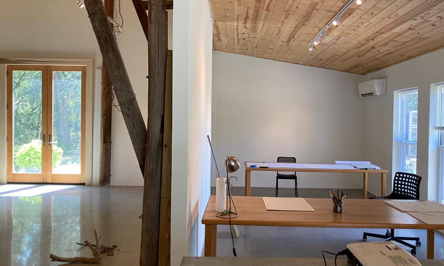 Semi-private barn studio space with large worktable and privacy curtain open