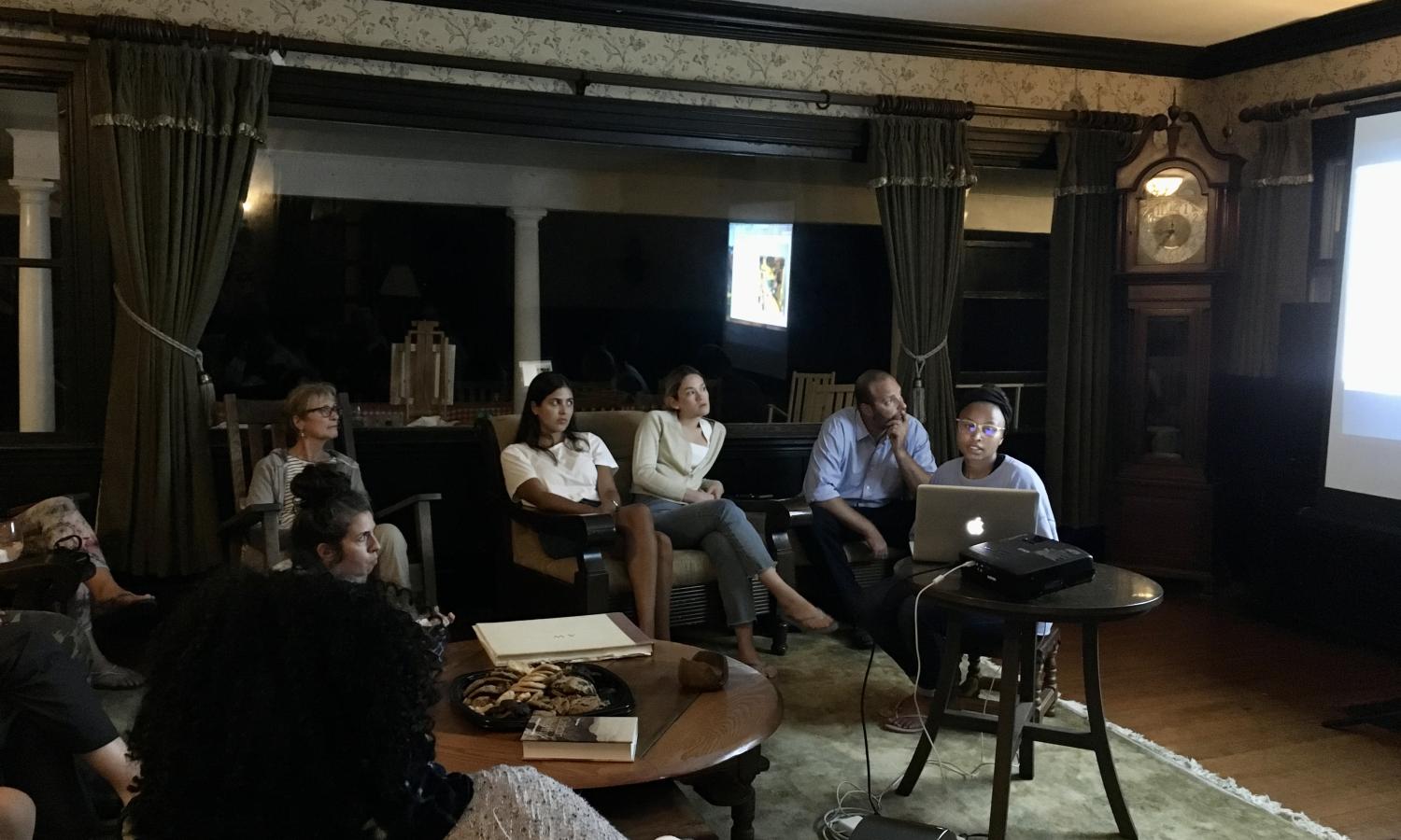 Artist in residence sharing a slide show of their work with the group