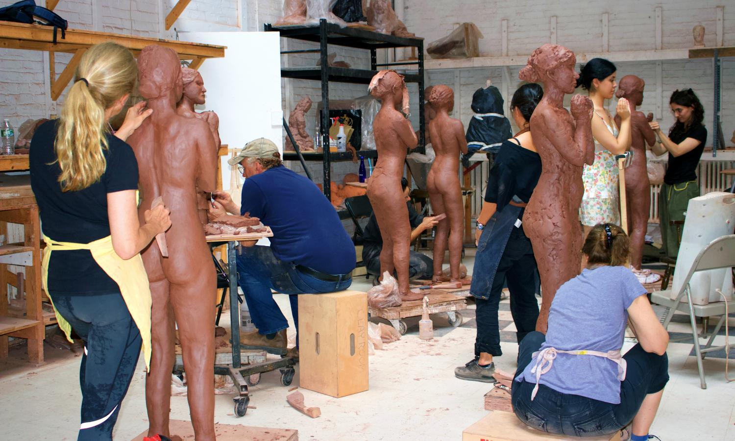 Students in NYSS Clay Room making life size figures.