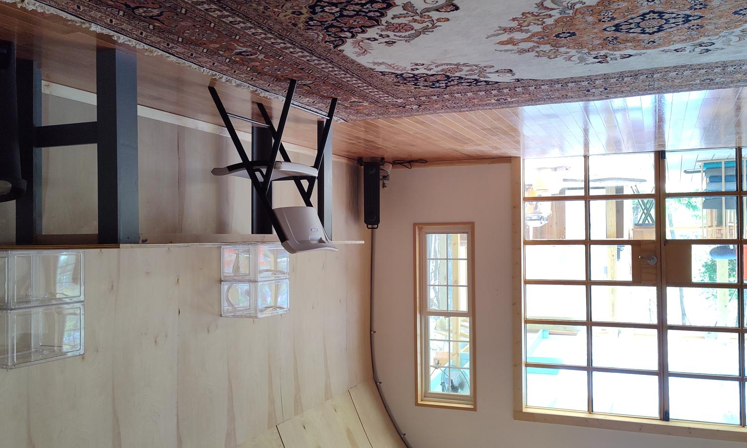 View of the interior of live work space to the outdoor porch area taken through large glass doors to the outside