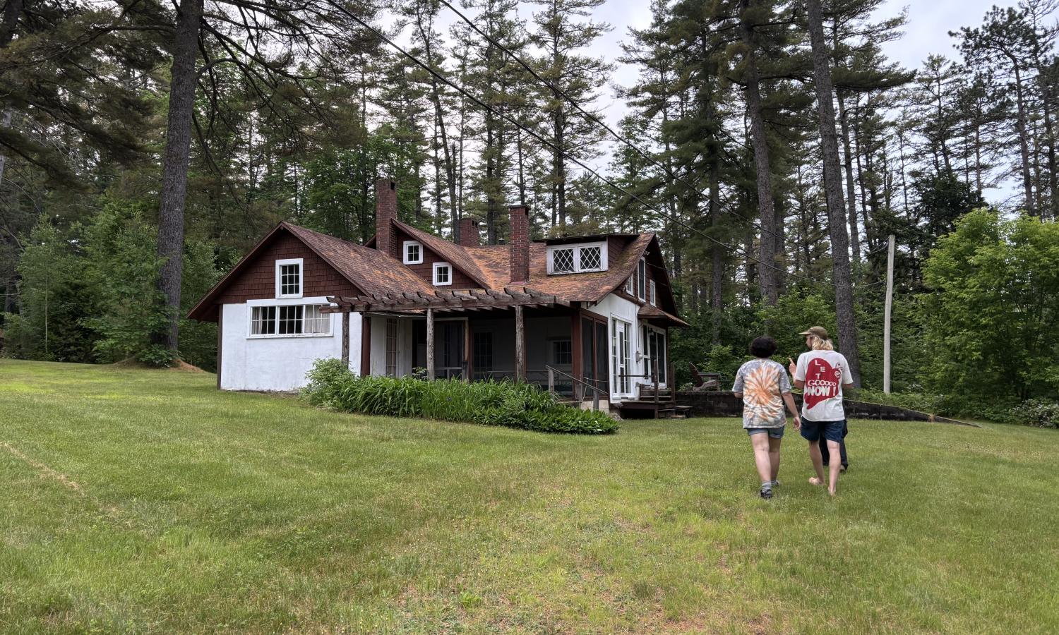 Two artists walk on the grass toward the main lodge