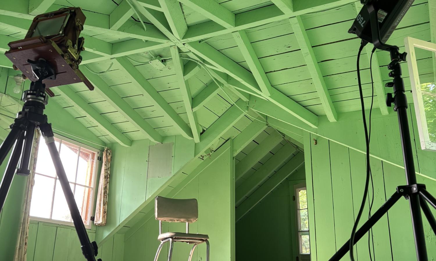 An orange balloon sits on the floor of a green-painted attic in one of Hewnoaks cabins