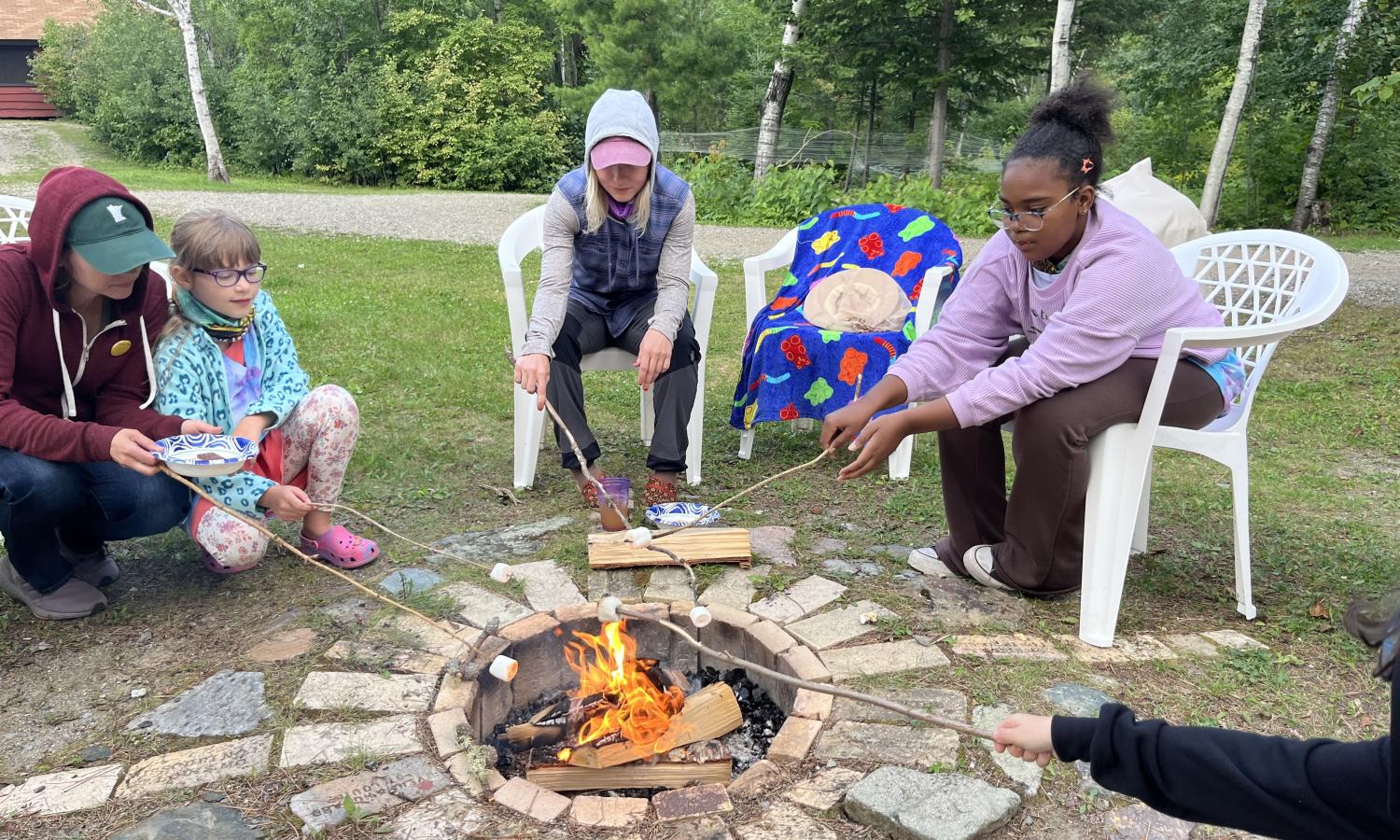 People roasting marshmallows around a campfire.