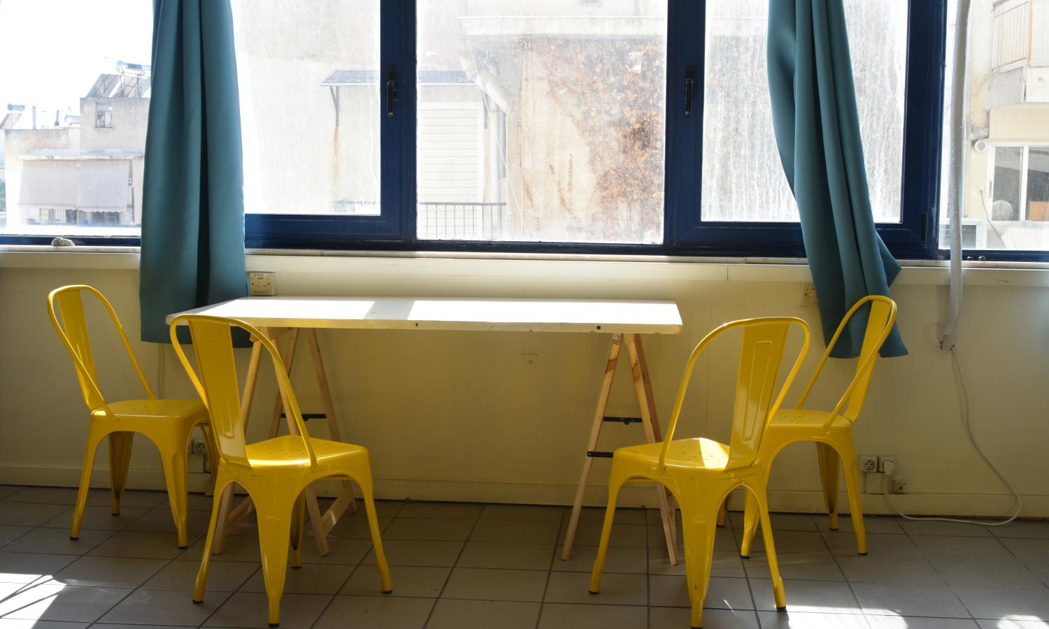 Communal table by bright sunlit windows in the studios