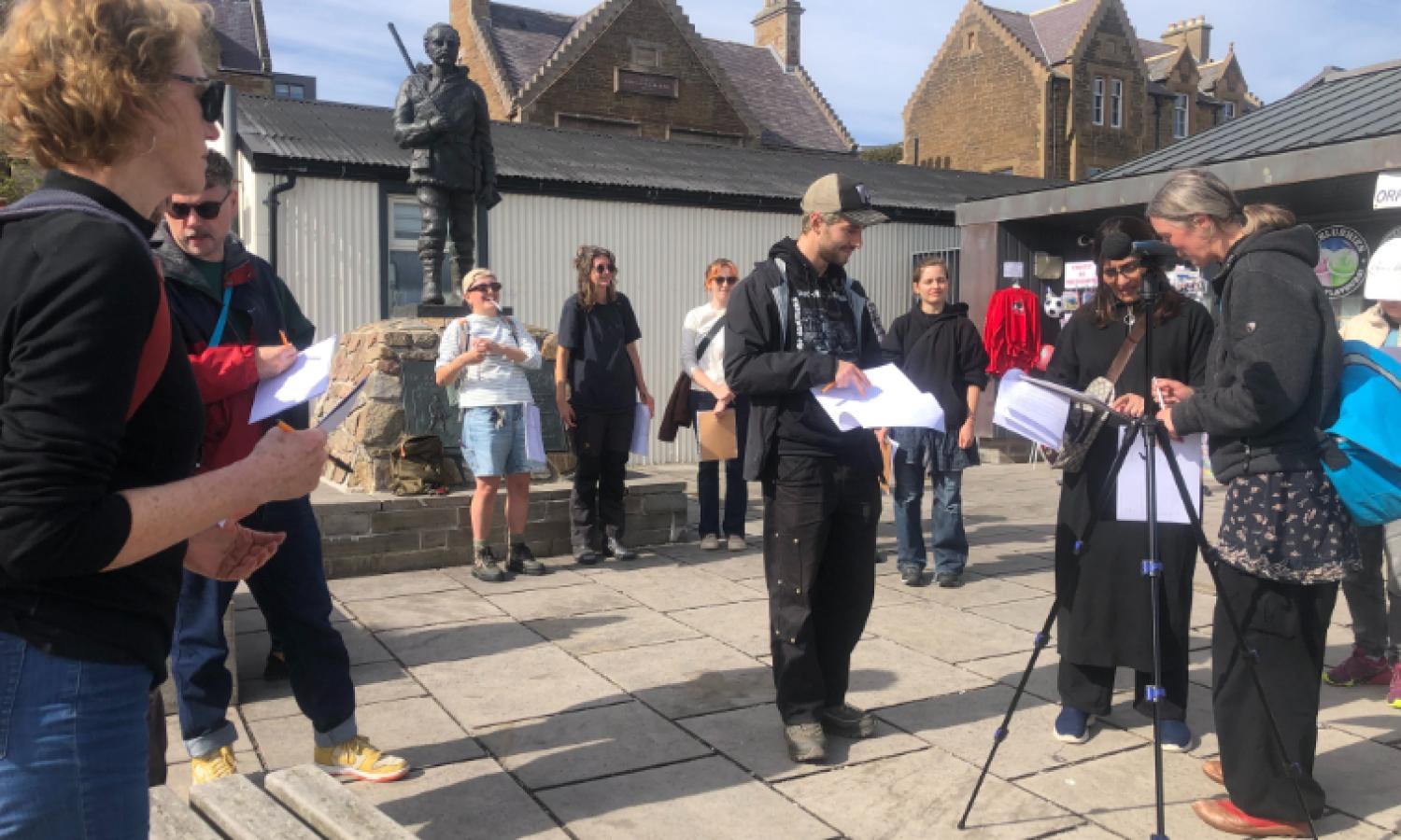 A group of people standing in a public square in a small town