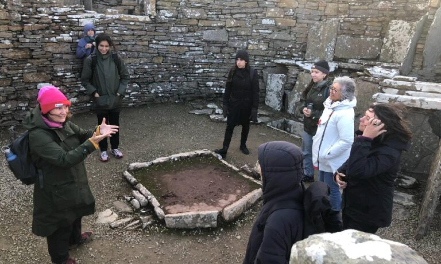 A group of people inside a broch - a stone-built iron-age structure