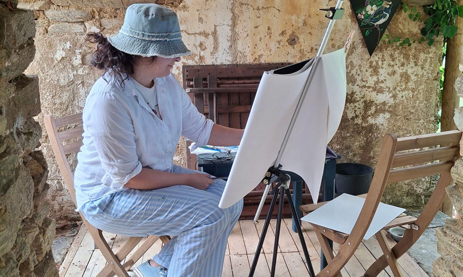 Landscape painter Nicole Smedile painting in an ancient wine press at the Water &amp; Rock art residency in Thassos, Greece