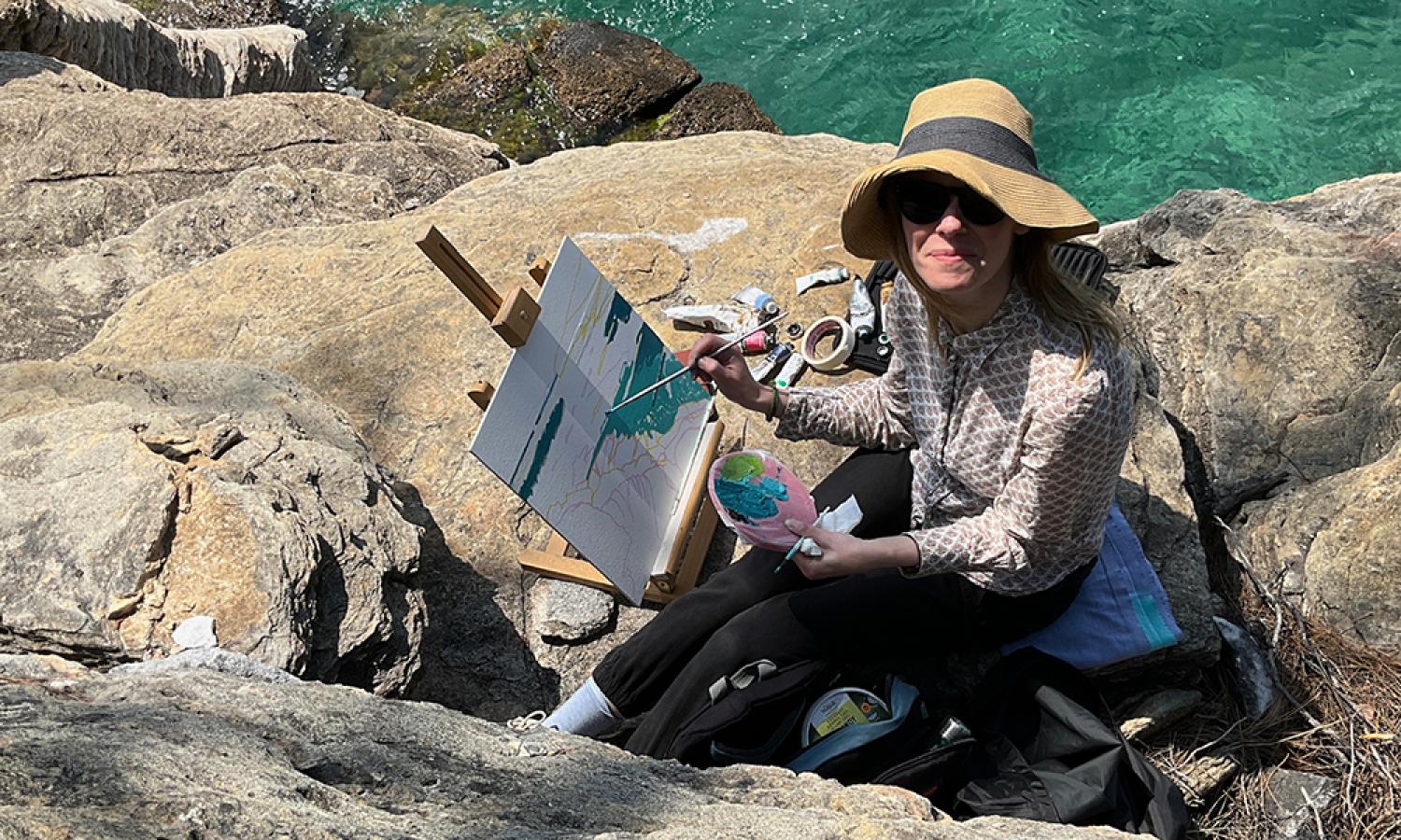 Water and Rock artist resident Rebecca Howard painting by the sea on the island of Thassos Greece