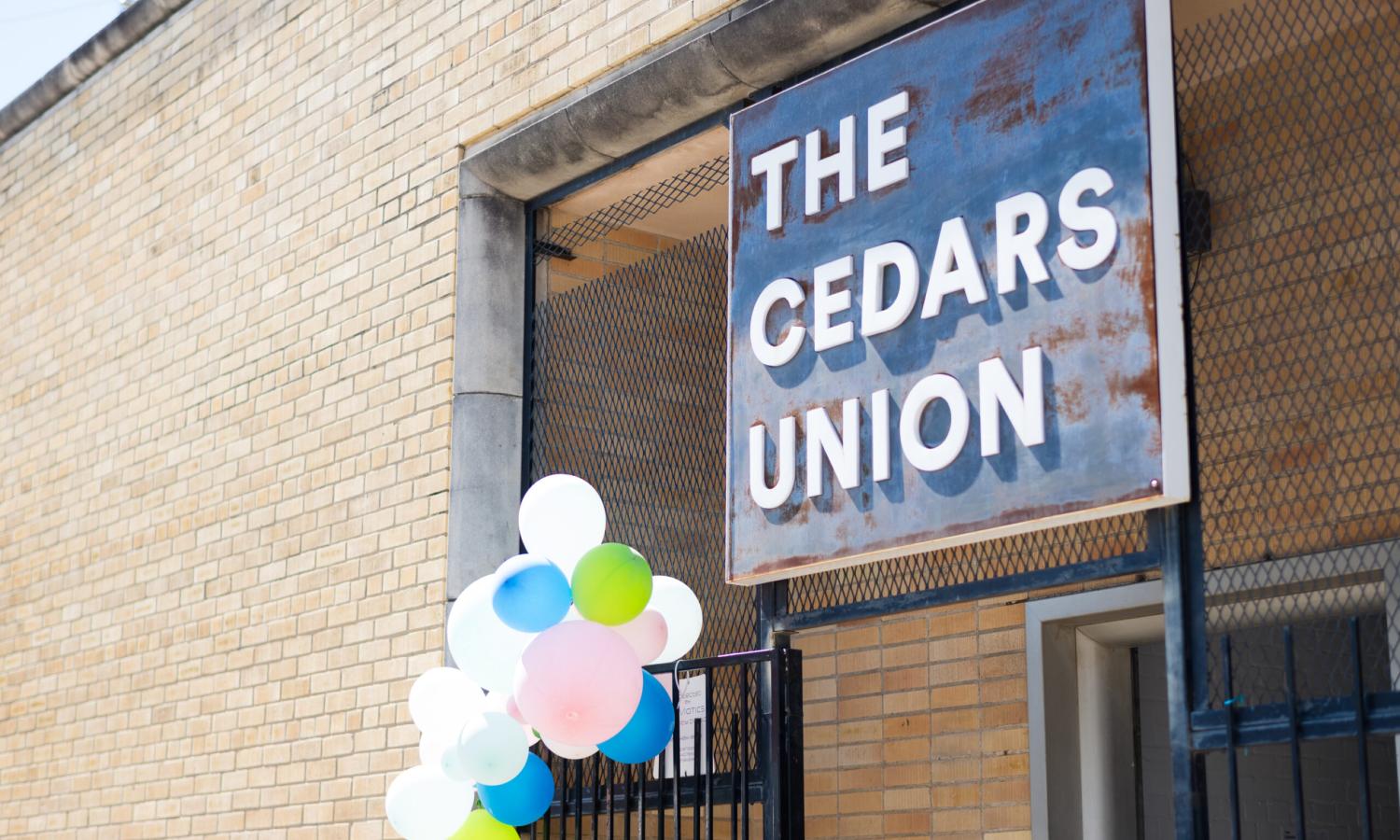 Image of the entrance to The Cedars Union building and it's sign bearing the organization name