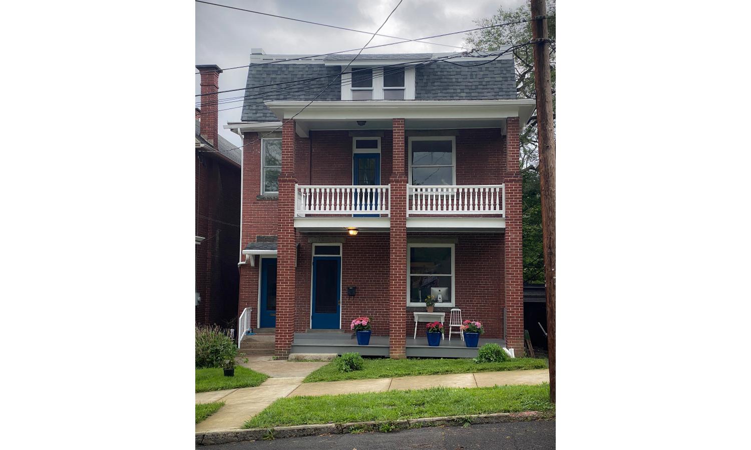 Brick house with upper and lower porches.