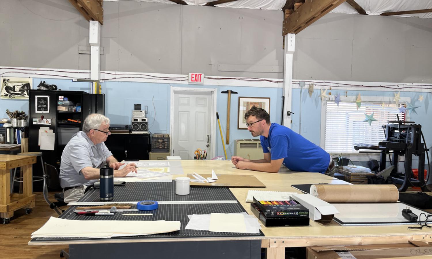 Resident artist, Wes McClure, consulting with printer at Obee Editions collaboration