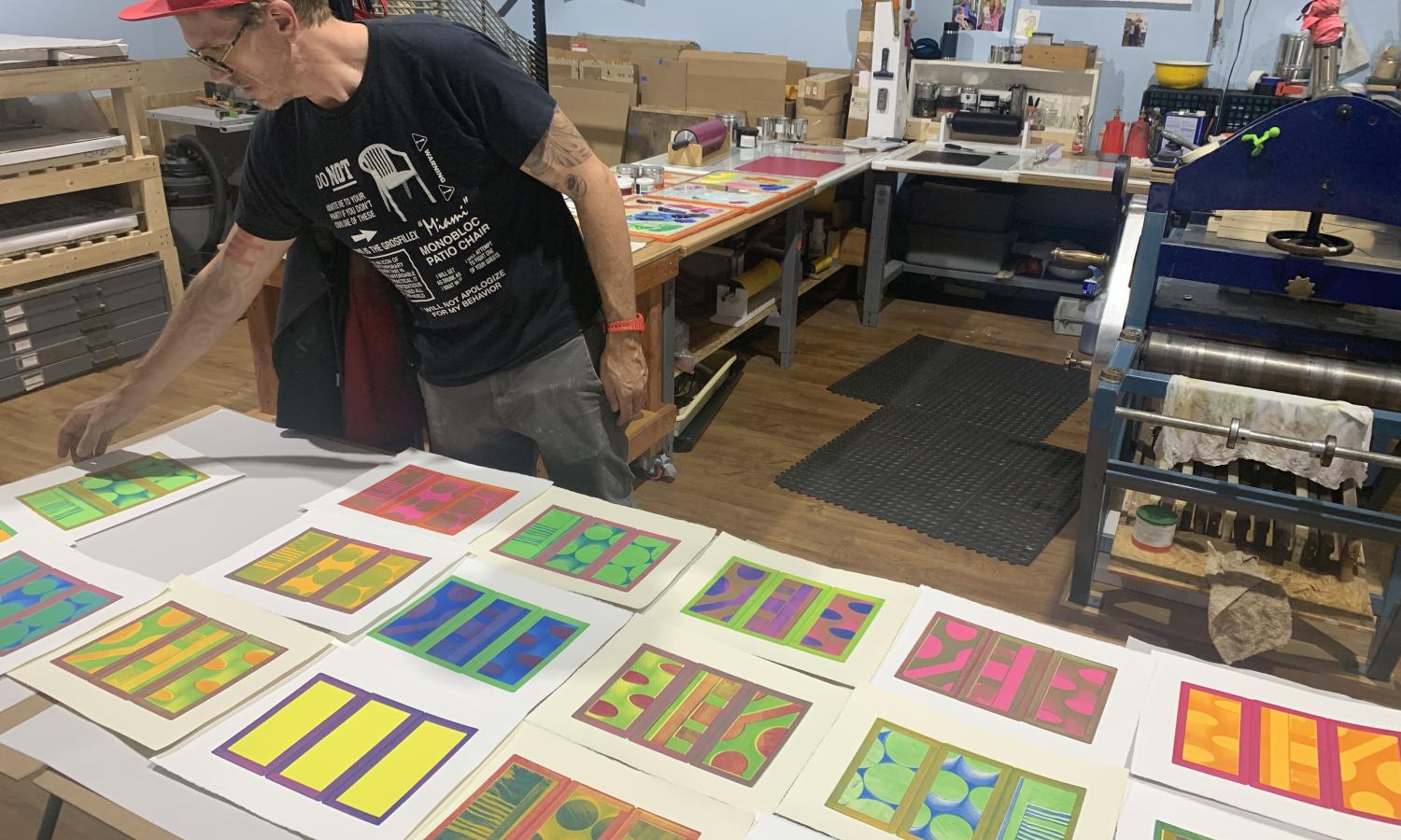 Resident artist, Philip Lique, laying out prints during residency at Obee Edition