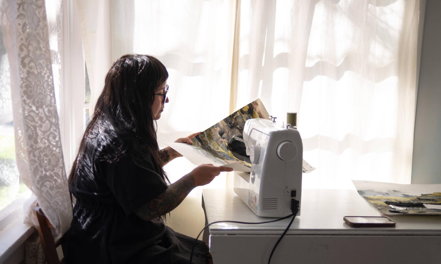 artist in residence sewing in historic cabin
