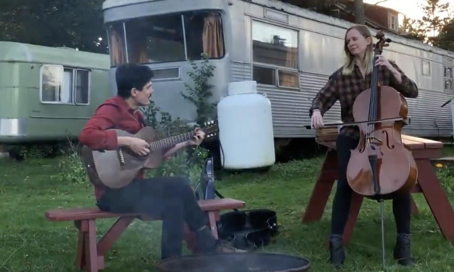 Musicians playing around a campfire