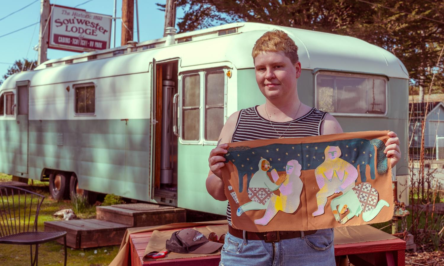 artist in residence showing work outside of vintage trailer