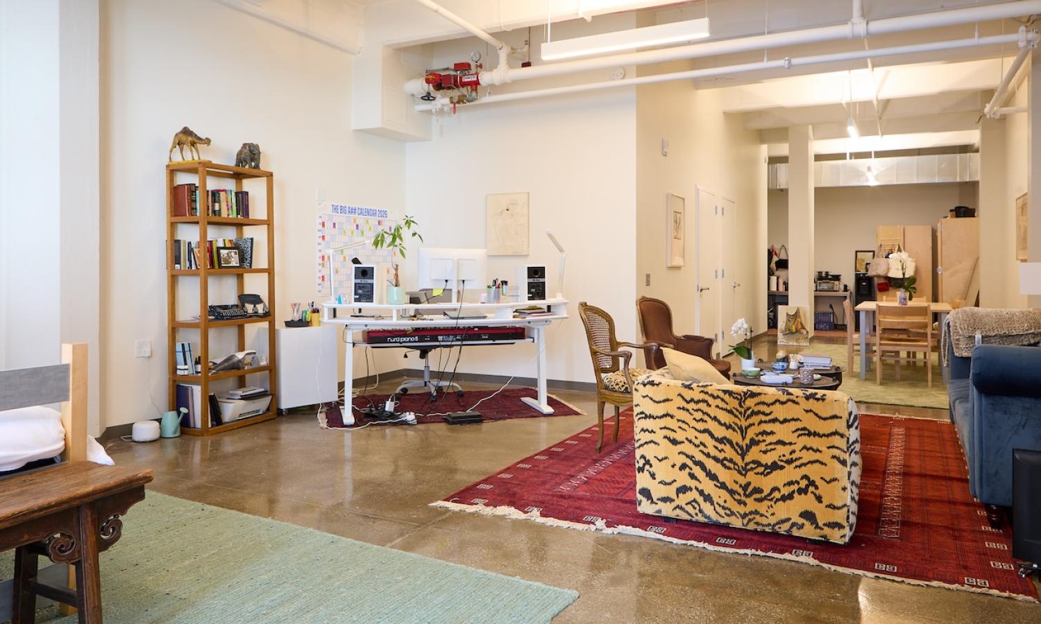 view of view of furnished live/work studio looking back toward the entrance with desk and sitting areas visible