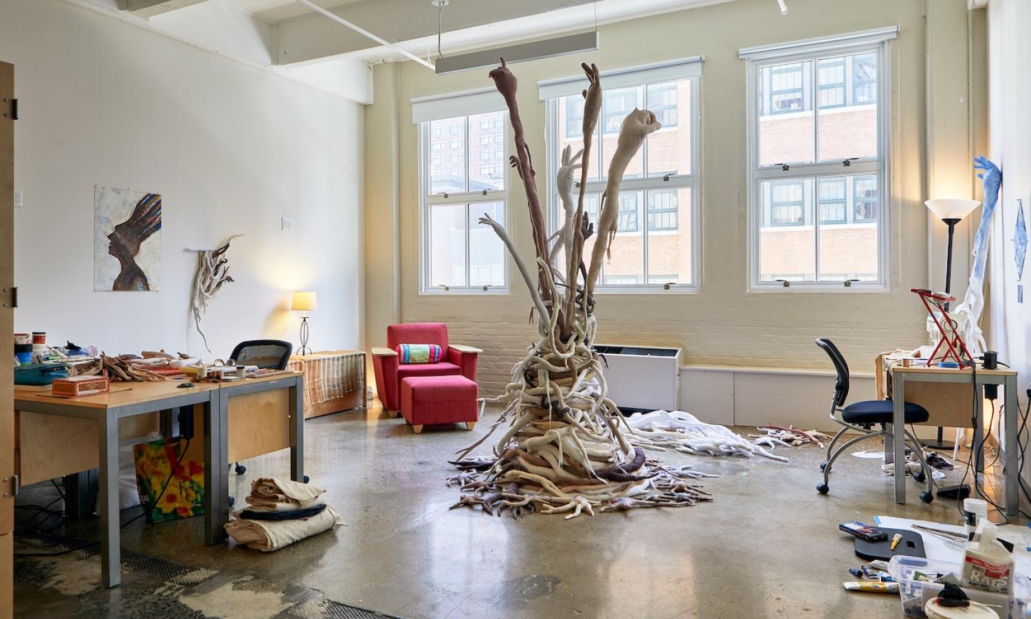 view of inhabited artist live/work studio showing desk and large textile sculpture