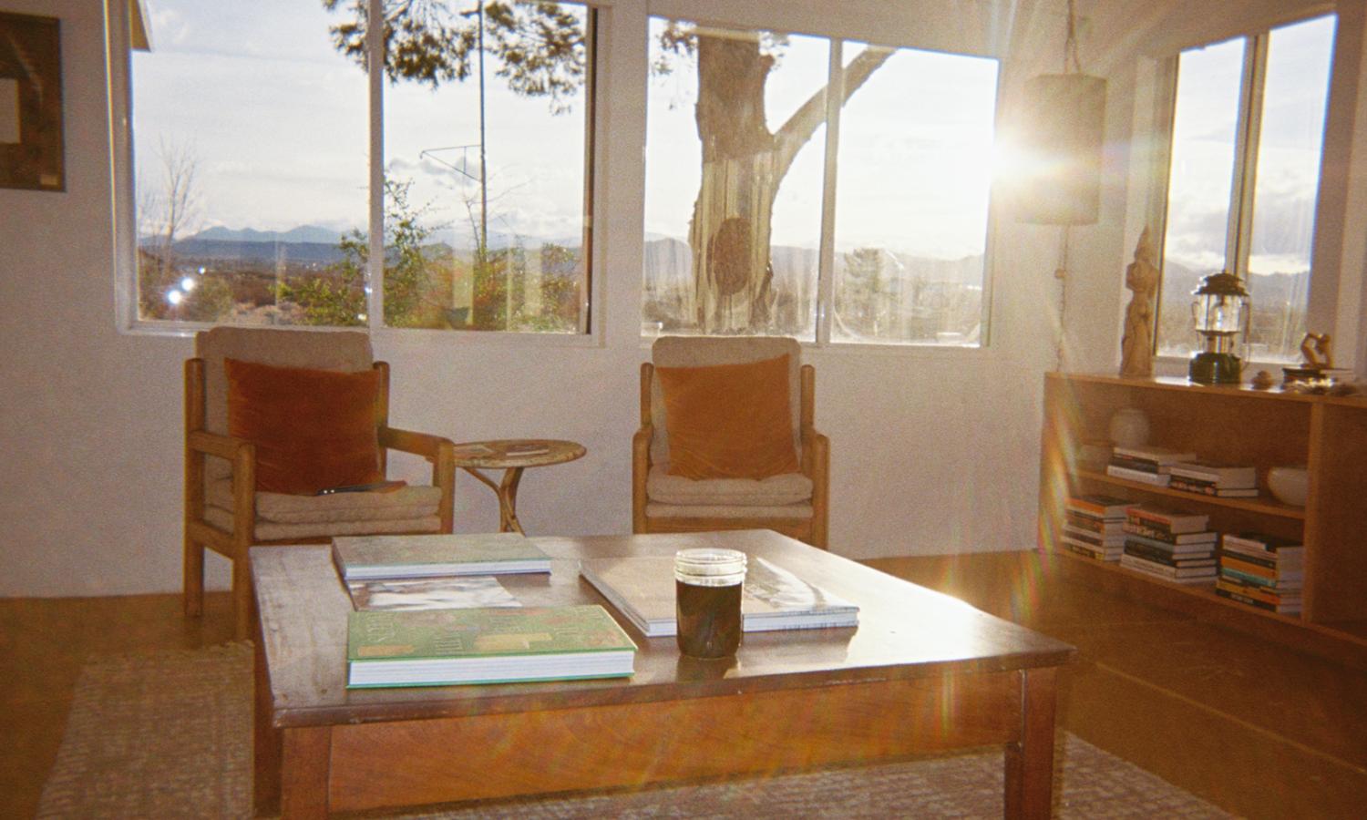 View of the main house living room with ample windows and the afternoon light pouring through